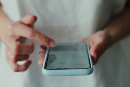 クレジットカードの引き落とし口座や名義確認をスマホで行う人物のイメージ
