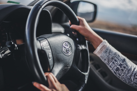 ハンドルを握って運転する人物のイメージ画像。家計を自分の手でコントロールしていく様子を象徴