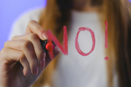 手で「NO」のジェスチャーをする女性の様子。補償対象外となるケースへの注意喚起を表現。