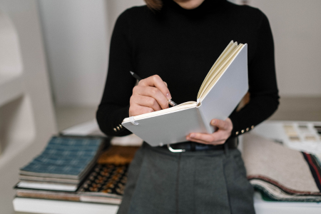 楽天カードの活用例を考えながら見本を作っている女性のイメージ