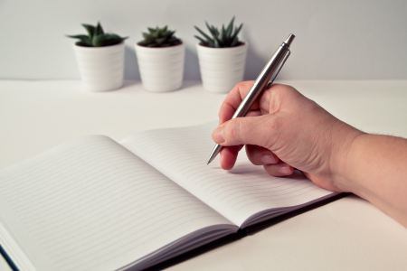 リボ払いの返済計画や注意点をノートに書き留めて管理している人のイメージ
