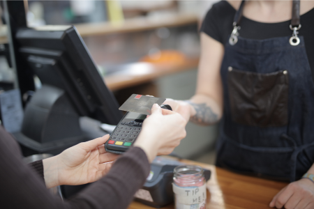 店舗でクレジットカード決済をしている様子のイメージ画像。お店が利便性や客単価向上を見込んで手数料を払ってでも導入する理由を表現