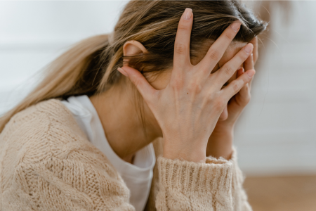 クレジットカードに不安を感じている若い女性の写真。真剣な表情で不安を訴える姿が印象的。